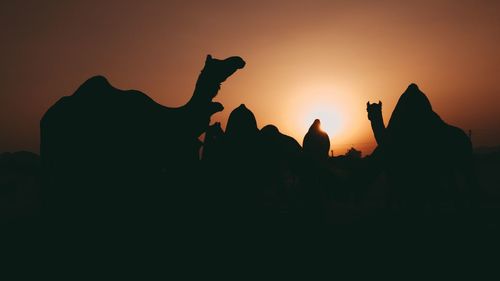 Silhouette people against sky during sunset