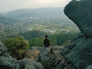 Portrait of smiling teenage boy standing on rock