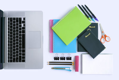 Directly above shot of books with laptop on white background