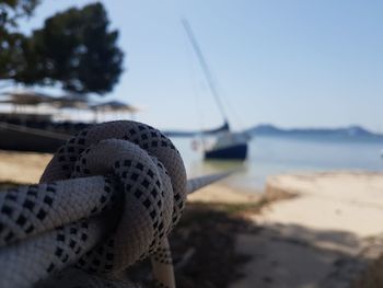 Close-up of shoes on beach against clear sky