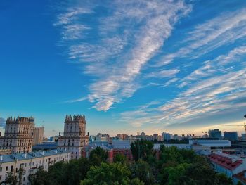 Buildings in city against cloudy sky