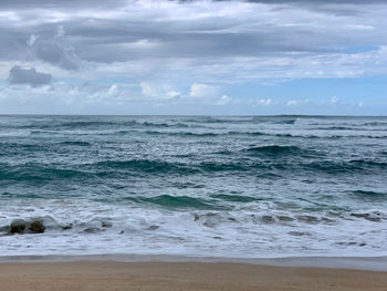 Scenic view of rough sea against sky