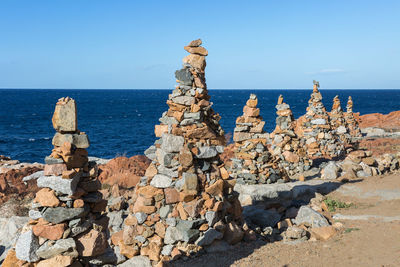 Stones piled on each other near coastline-rocks and cliffs near sea.