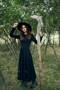 Portrait of young woman standing on field