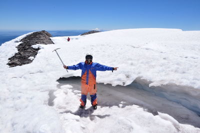 Rear view of man standing on snow covered landscape