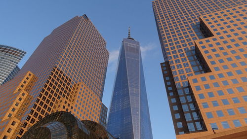 Low angle view of tall buildings against blue sky