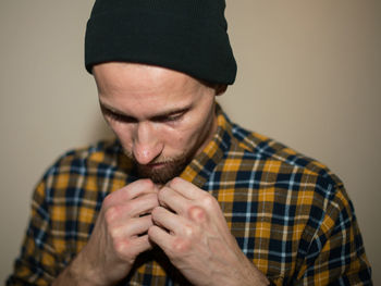 Portrait of man wearing hat against gray background