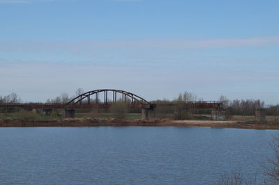 Arch bridge over river against sky