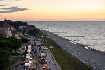 High angle view of sea and buildings against sky during sunset