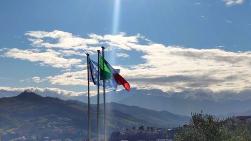 Low angle view of flags on mountain against sky