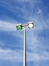 Low angle view of illuminated street light against cloudy sky