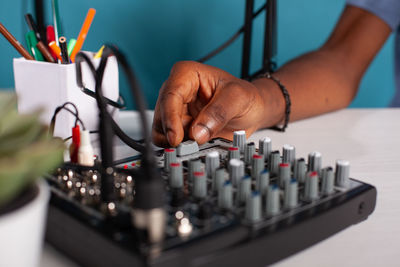 Cropped hand of vlogger using audio console