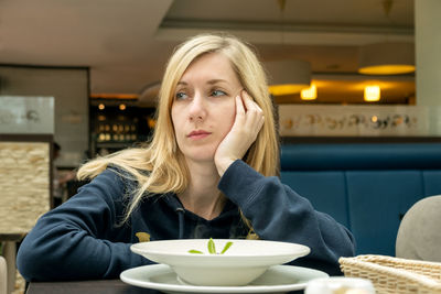 Portrait of young woman sitting at home