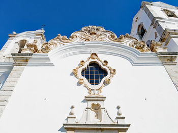 Low angle view of sculpture and building against clear sky