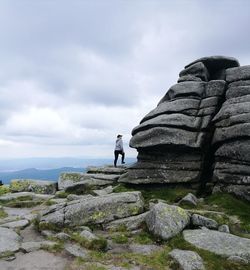 Woman walking on cliff against sky