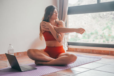Side view of young woman exercising in gym