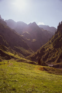 Scenic view of valley and mountains against sky