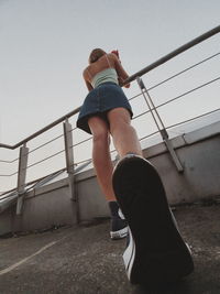 Rear view of man on staircase against sky