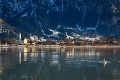 Scenic view of lake by buildings against sky