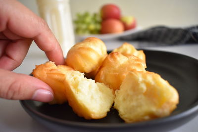 Close-up of hand holding food in plate