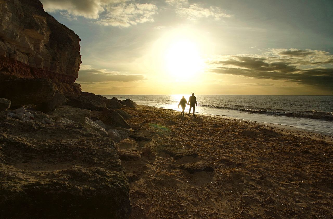 sunset, sea, sky, nature, beach, water, togetherness, rock - object, real people, walking, beauty in nature, horizon over water, men, scenics, rear view, leisure activity, tranquility, cloud - sky, two people, lifestyles, outdoors, standing, full length, friendship, day, adult, people