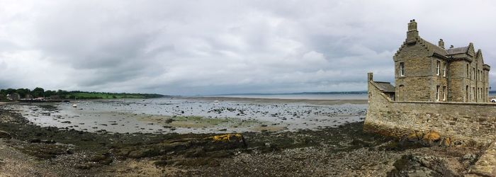 Panoramic view of old building by sea against sky