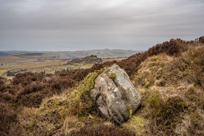 Scenic view of rocks on field against sky