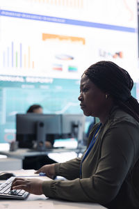 Side view of man using laptop at cafe