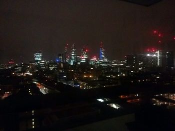 Illuminated cityscape against sky at night