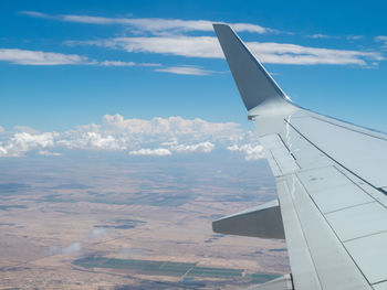 Airplane flying over landscape against sky