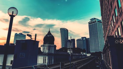 Buildings in city against cloudy sky