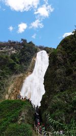 Scenic view of waterfall against sky