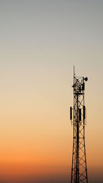 Low angle view of silhouette electricity pylon against sky during sunset