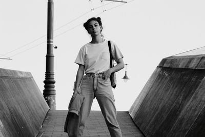 Low angle view of young man standing against sky