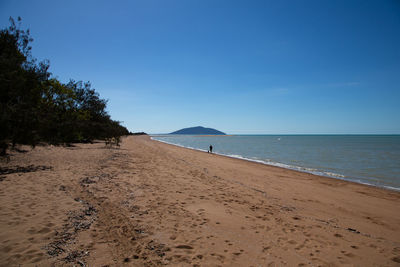 Scenic view of beach against blue sky