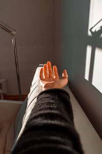 Close-up of cropped hand on sofa at home