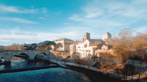 Bridge over river against buildings in city