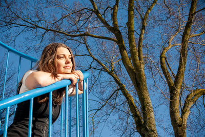 Low angle view of a woman against blue sky