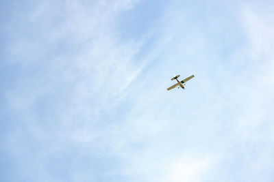 Low angle view of airplane flying against sky