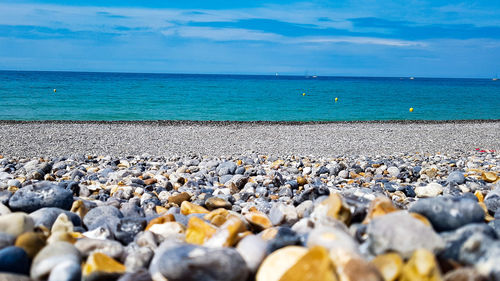 Surface level of stones on beach against sky