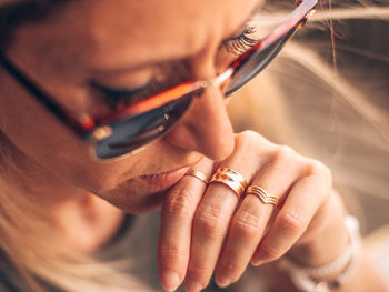 High angle close-up of mature woman wearing sunglasses while sitting indoors