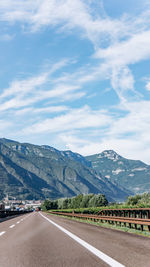 Road by mountains against sky