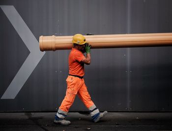 Man standing in front of orange umbrella