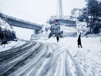 People on snow covered mountain in city