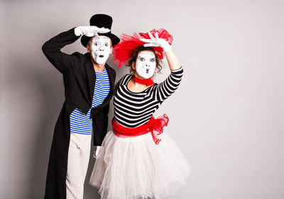 Portrait of young couple standing against red background