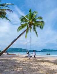 People at beach against sky