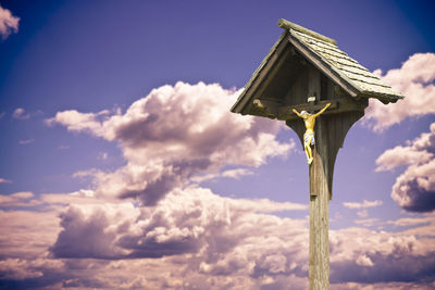 Low angle view of cross against sky