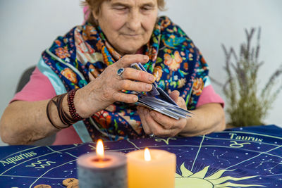 Midsection of woman holding lit candle