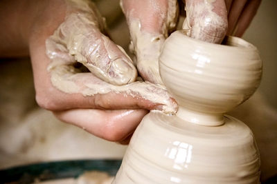 A man with his hands dub wall jug, which he sculpts out of clay on a circle. create clay vessel. 