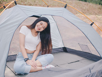 Portrait of young woman sitting in tent